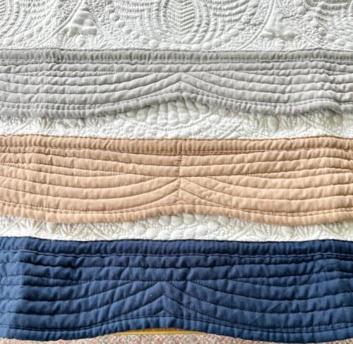 Gray, beige, and navy borders on white quilted baby blanket