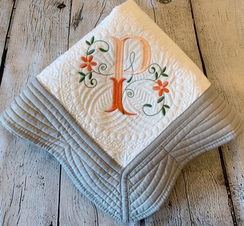 Quilted baby blanket with decorative embroidered initial